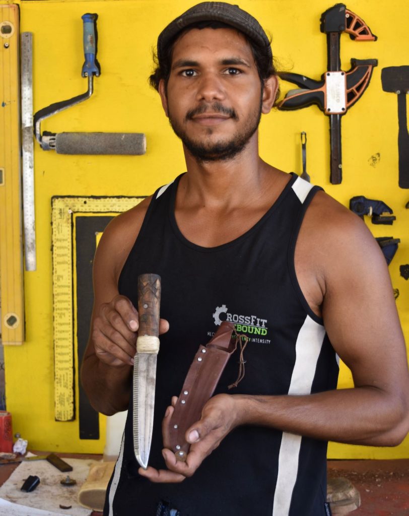 Illiam Nargoodah holds one of his handmade knives in a workshop