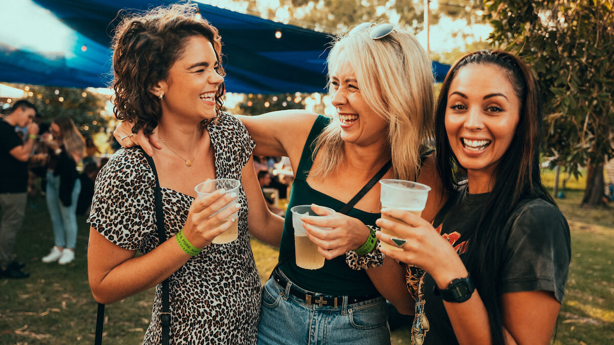 three women laughing while holding cups of cider at WA Cider and Pork Festival